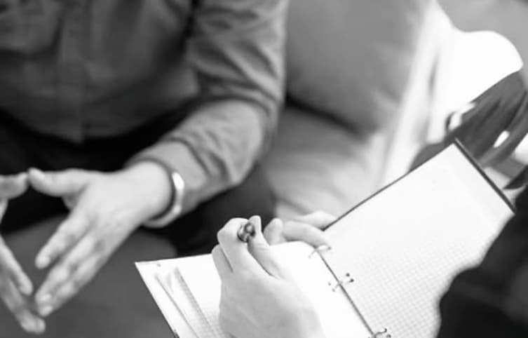 A therapist taking notes during a session